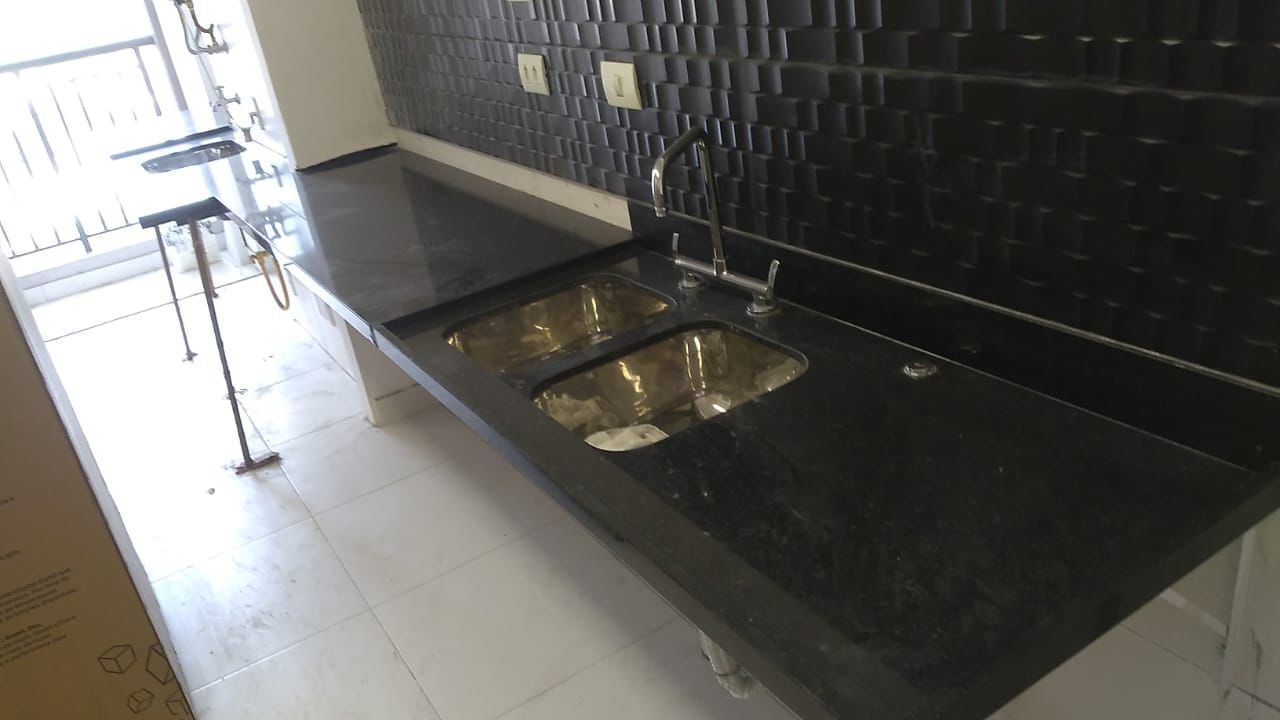 Bancada de cozinha em granito preto com duas cubas de inox e escorredor esculpido